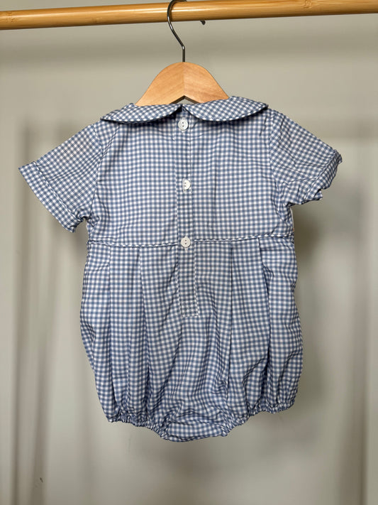 Blue checkered baby romper on a hanger against a plain background