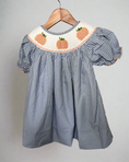 Load image into Gallery viewer, Blue checkered dress with pumpkin embroidery on a hanger against a neutral background