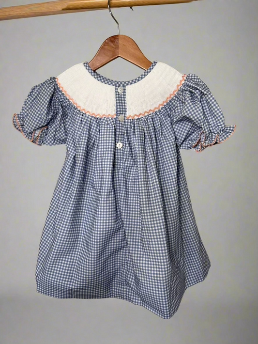 Blue checkered dress with white collar on a wooden hanger against a neutral background