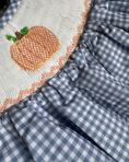 Load image into Gallery viewer, Close-up of a blue and white checkered fabric with a embroidered pumpkin design.
