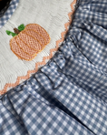 Load image into Gallery viewer, Close-up of a blue and white checkered fabric with an embroidered pumpkin design.